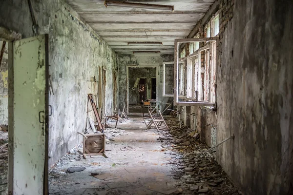 Corridoio della scuola con detriti e finestre rotte — Foto Stock