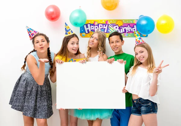 Teenagers at a birthday party holding banner — Stock Photo, Image