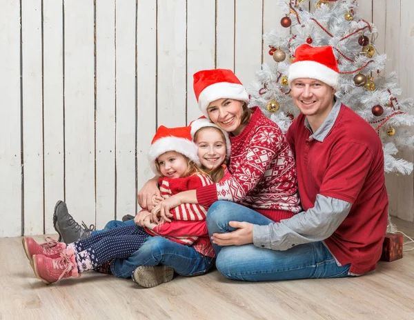 Velká rodina v červené santa klobouky u vánočního stromu — Stock fotografie