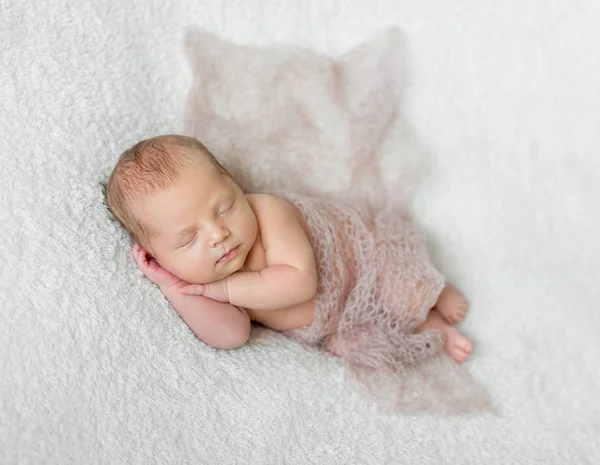 Mooie slapende baby bedekt met lichte gebreide omslagdoek — Stockfoto
