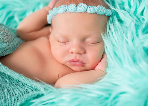 Zoet slapende pasgeboren meisje met bloemen op hoofdband — Stockfoto