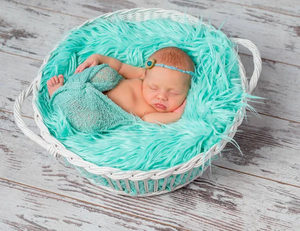 Hermosa niña recién nacida durmiendo en cuna redonda con manta de color turquesa —  Fotos de Stock