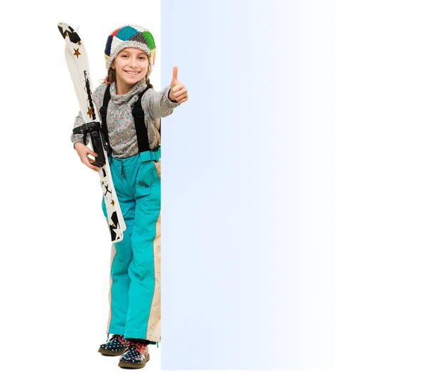 Petite fille avec des skis pointant vers un blanc vide — Photo