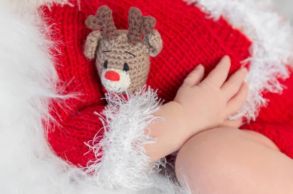 Niedliches schlafendes Baby mit rotem Hut auf kleinem Bett — Stockfoto