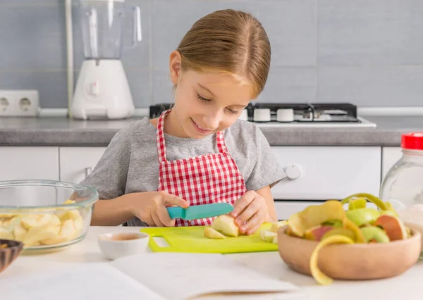 Nettes kleines Mädchen schneidet Äpfel für Strudel — Stockfoto