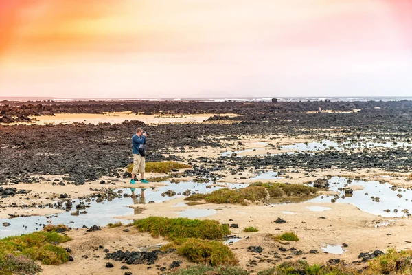 Turystyczna biorąc zdjęcie na kamienisty brzeg Wyspy Kanaryjskie — Zdjęcie stockowe
