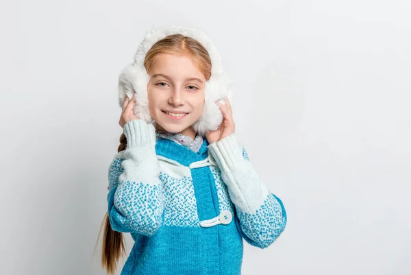 Menina sorridente bonito em fones de ouvido de pele quente — Fotografia de Stock