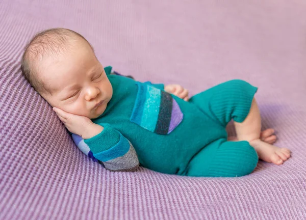 Schattig baby in warme overalls slapen op deken — Stockfoto