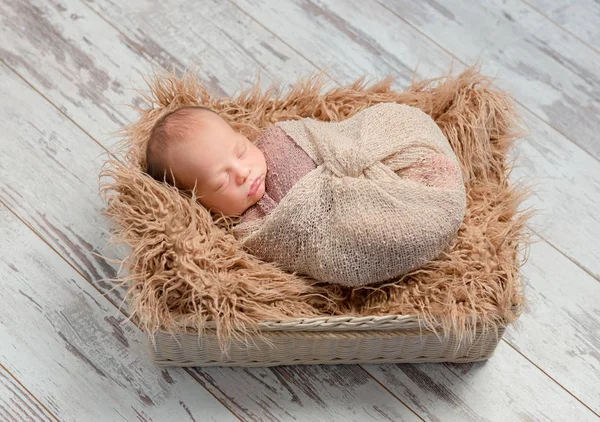 Schöne schlafende Baby in Korb mit flauschiger Decke gewickelt — Stockfoto