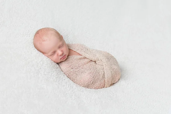 Krásné spící dítě zabalené v béžové plenka — Stock fotografie