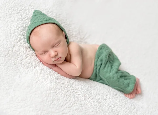 Cute newborn sleeping in green elf hat and panties — Stock Photo, Image