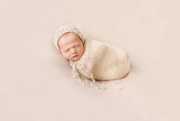 Precioso bebé envuelto en sombrero durmiendo en una manta beige —  Fotos de Stock