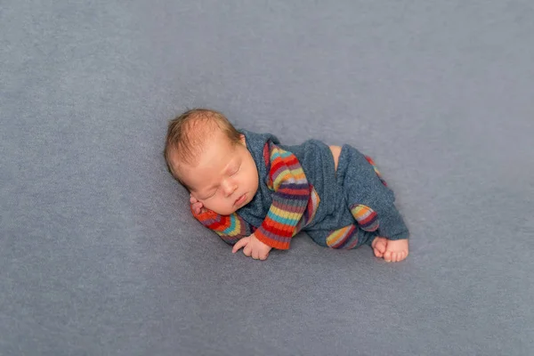 Hairy newborn in striped outfit — Stock Photo, Image