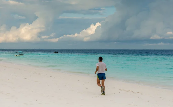 Człowiek, jogging rano na Zanzibar beach — Zdjęcie stockowe