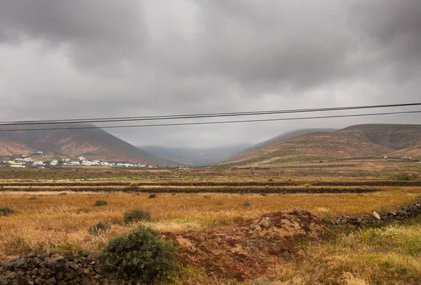 Campos con pueblo y montañas al fondo en Lanzarote — Foto de Stock