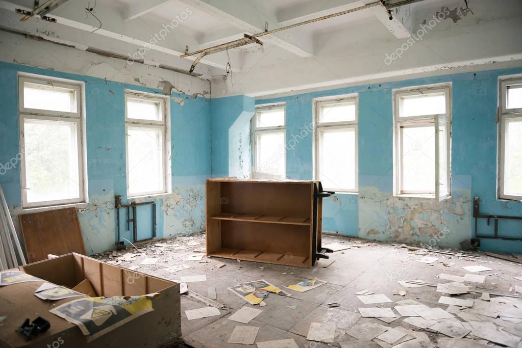 room with overturned furniture in ruin in forsaken Pripyat