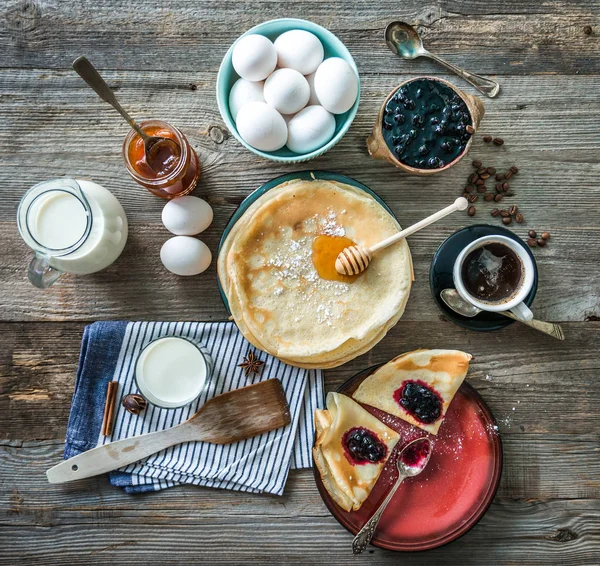 Prepared pancakes and coffee among ingredients — Stock Photo, Image