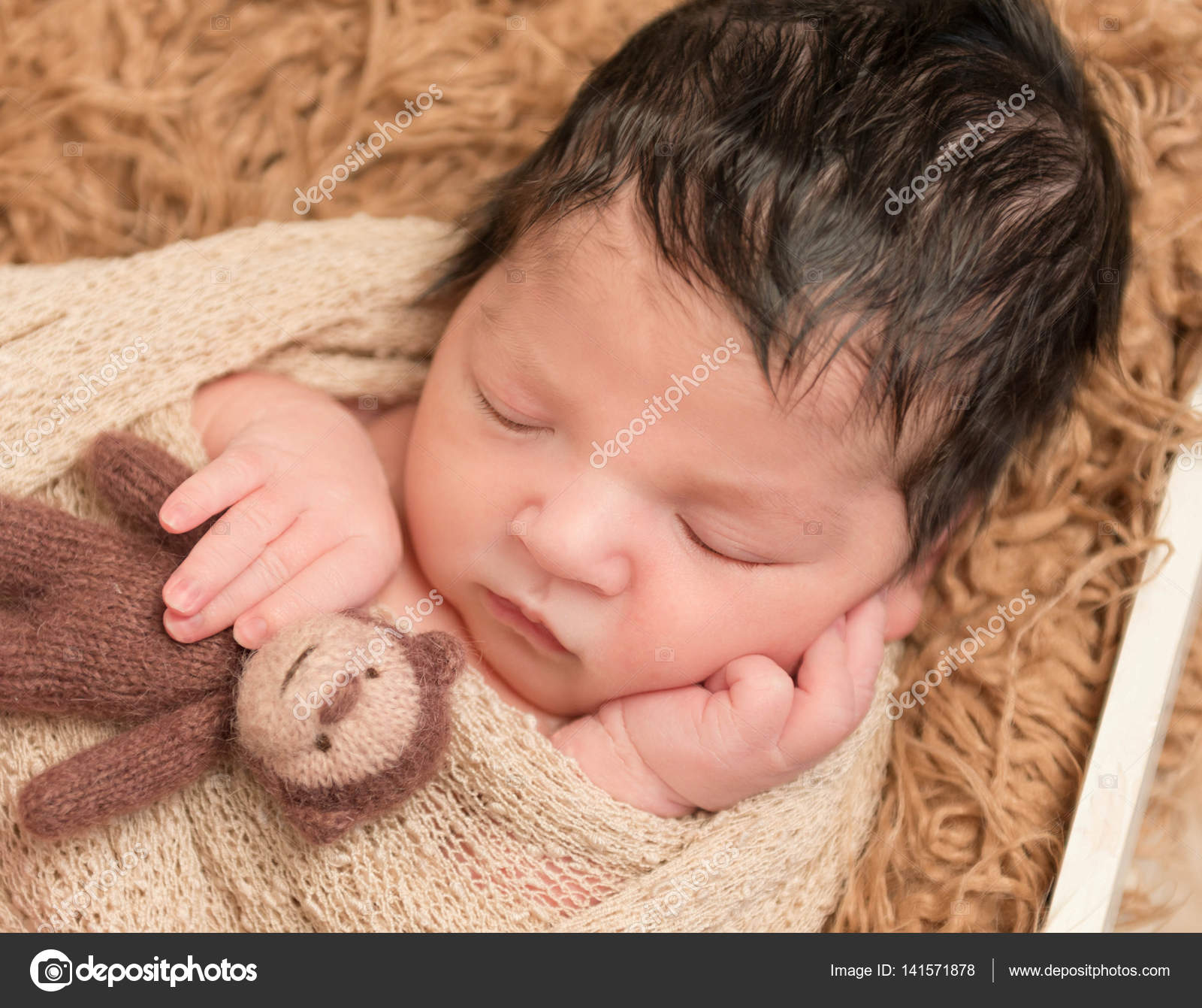 Recién nacido de pelo negro con juguete de mono, primer plano