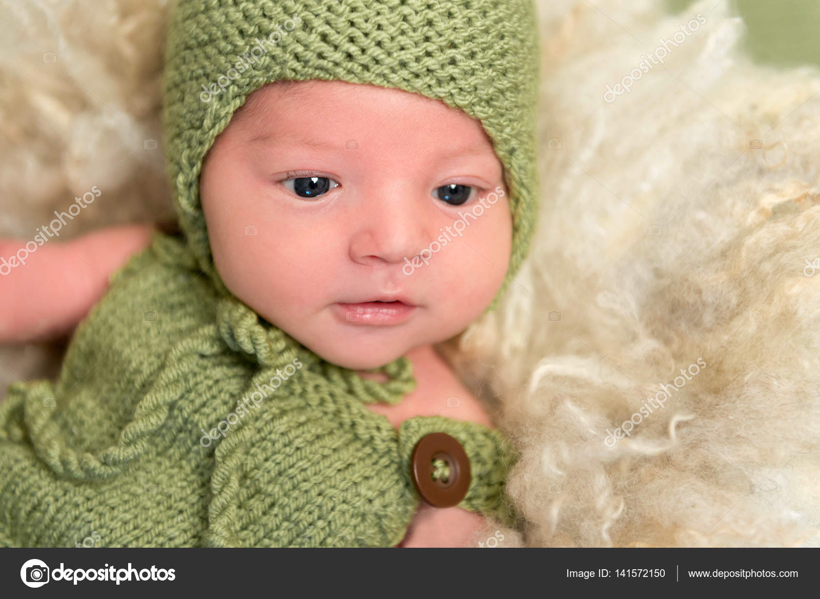 Baby in a knitted green outfit, closeup Stock Photo by ©tan4ikk