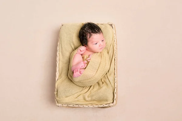 Panier bébé aux cheveux noirs enveloppé, vue de dessus — Photo