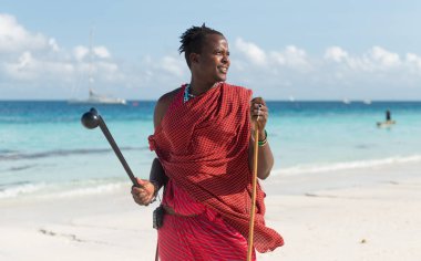 Bununla birlikte güneş gözlüklü bir plajda Masai gülümseyen