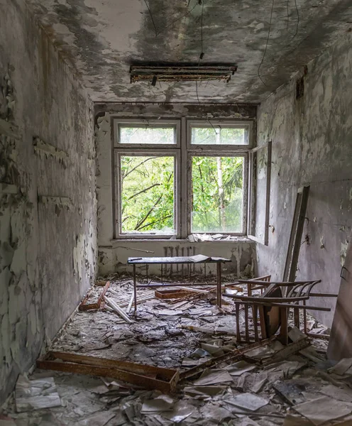 Escola abandonada estudo com detritos e móveis quebrados — Fotografia de Stock