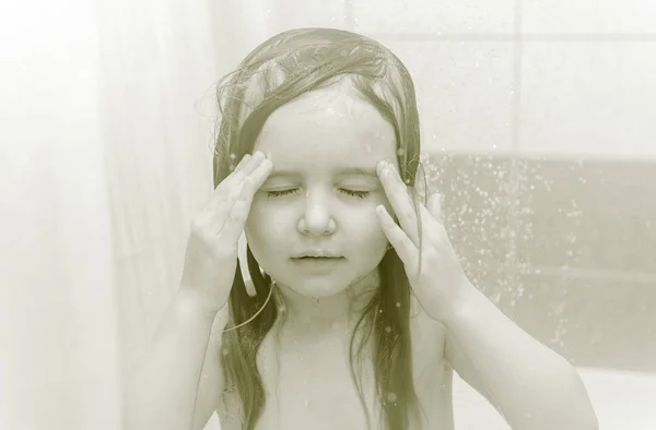 Enfant avec de longues éclaboussures de cheveux foncés, douche — Photo