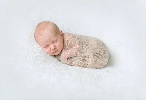 Mooie slapende baby verpakt in beige luier — Stockfoto