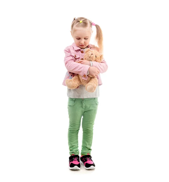 Adorável menina abraçando brinquedo, isolado no fundo branco — Fotografia de Stock