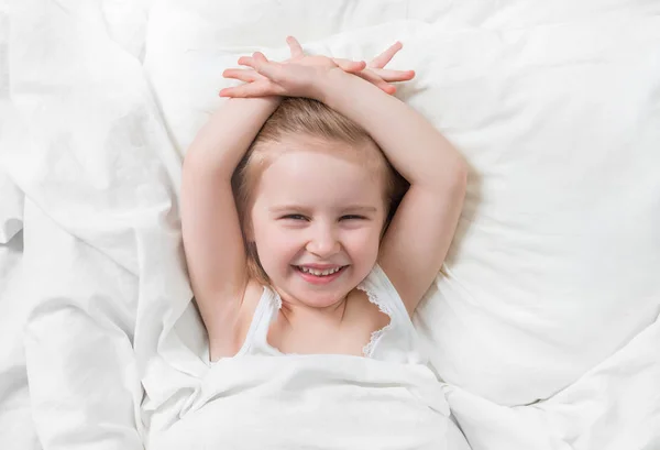 Schöne Gefühle der Tochter, die im Bett lächelt — Stockfoto