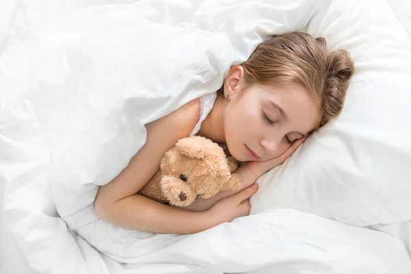 Child hugging her teddy bear in sleep — Stock Photo, Image