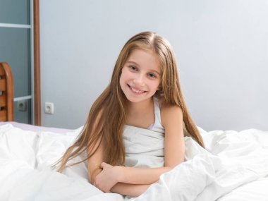 pijamalar içinde oturan uzun saçlı çocuk