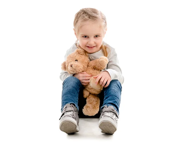 Kid sitting and hugging teddy, isolated — Stock Photo, Image