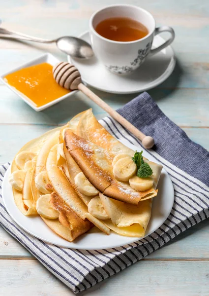 Pancake stack filled with banana slices and honey — Stock Photo, Image