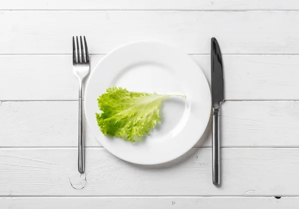 Assiette blanche avec laitue, végétarienne, vue de dessus — Photo