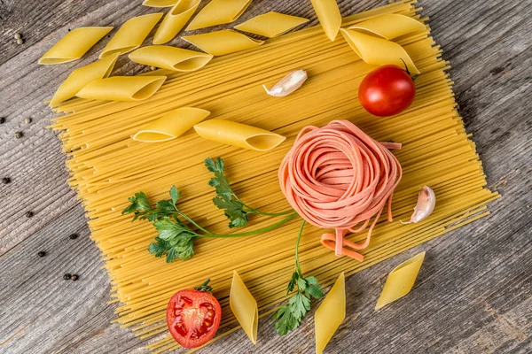 Spaghetti, rose looking macaroni in composition, topview — Stock Photo, Image