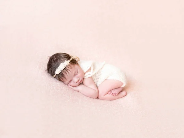 Curled up baby in knitted pastel costume — Stock Photo, Image