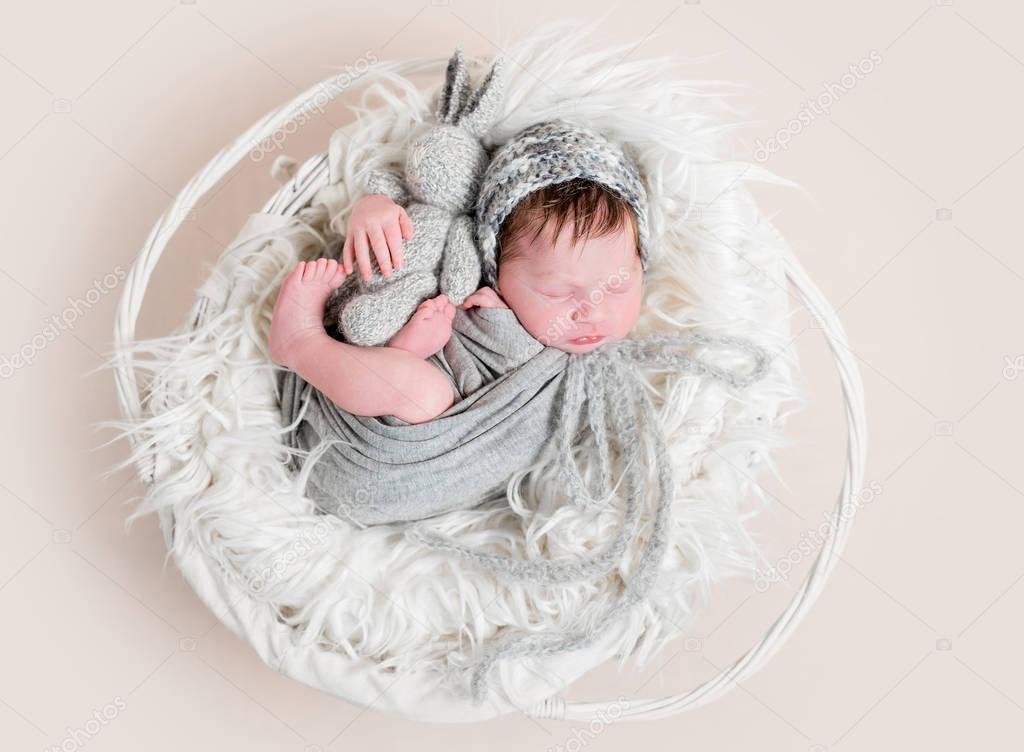 baby in wrapping napping in basket, topview