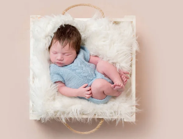 Baby klädd i blå stickad dräkt, topview — Stockfoto