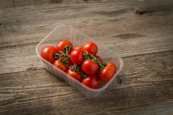 Tomates sentados en el recipiente plásico —  Fotos de Stock