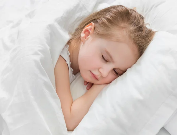 Doce menina cochilando, cobertor branco macio — Fotografia de Stock