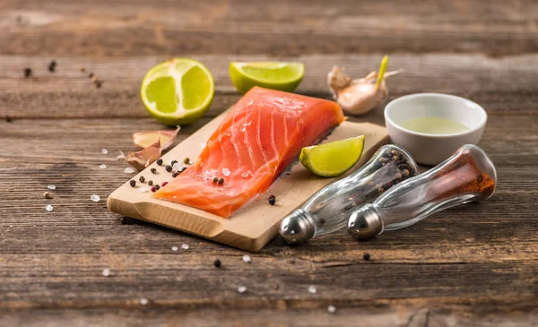 Filete de salmón sobre mesa con limón cortado —  Fotos de Stock