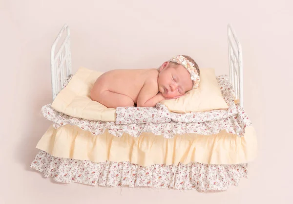 Spädbarn sover på säng med gula blad — Stockfoto