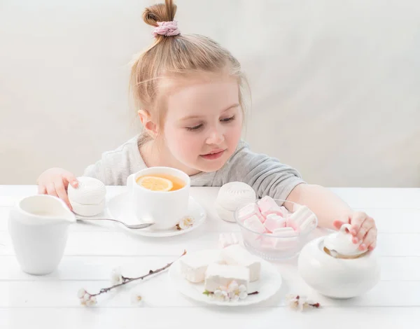 Little girl with sweets around her — Stock Photo, Image