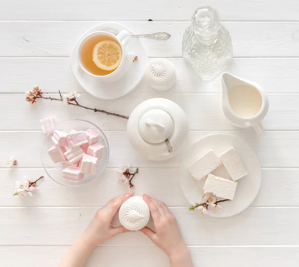 Крошечные руки держат сладости для чайной церемонии, вид сверху — стоковое фото