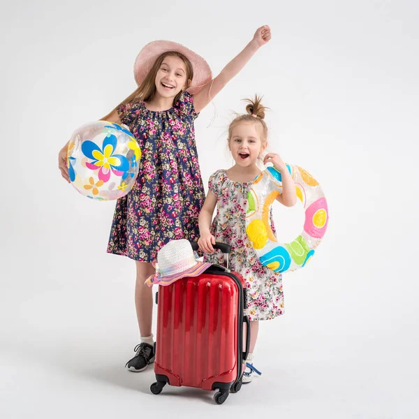 Hermanas felices paradas cerca de una maleta — Foto de Stock