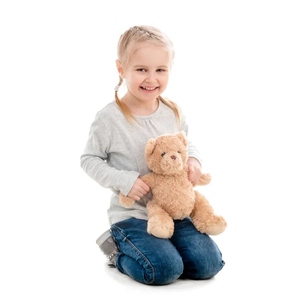 Kid sentado e abraçando teddy, isolado — Fotografia de Stock