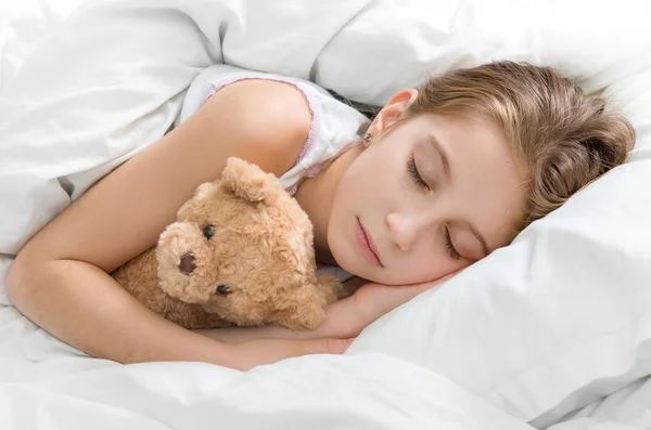 Niño abrazando a su osito de peluche en el sueño — Foto de Stock