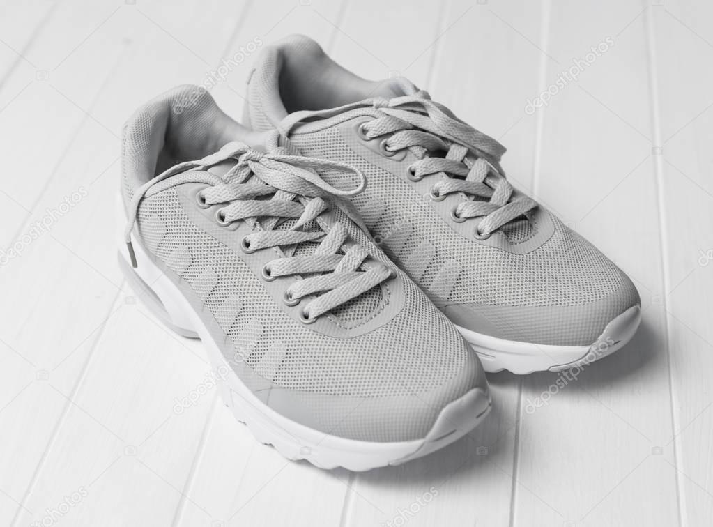 Gray cozy running shoes sitting on wood