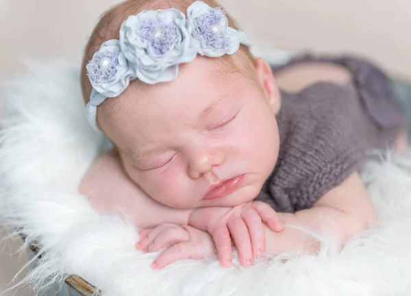 Spädbarn flicka med blommigt hårband sover — Stockfoto